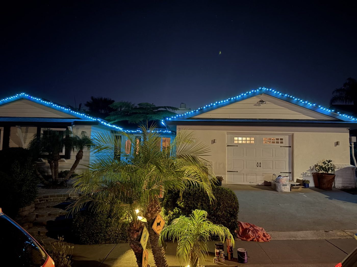 San Diego home with blue roofline lights and a lit palm tree